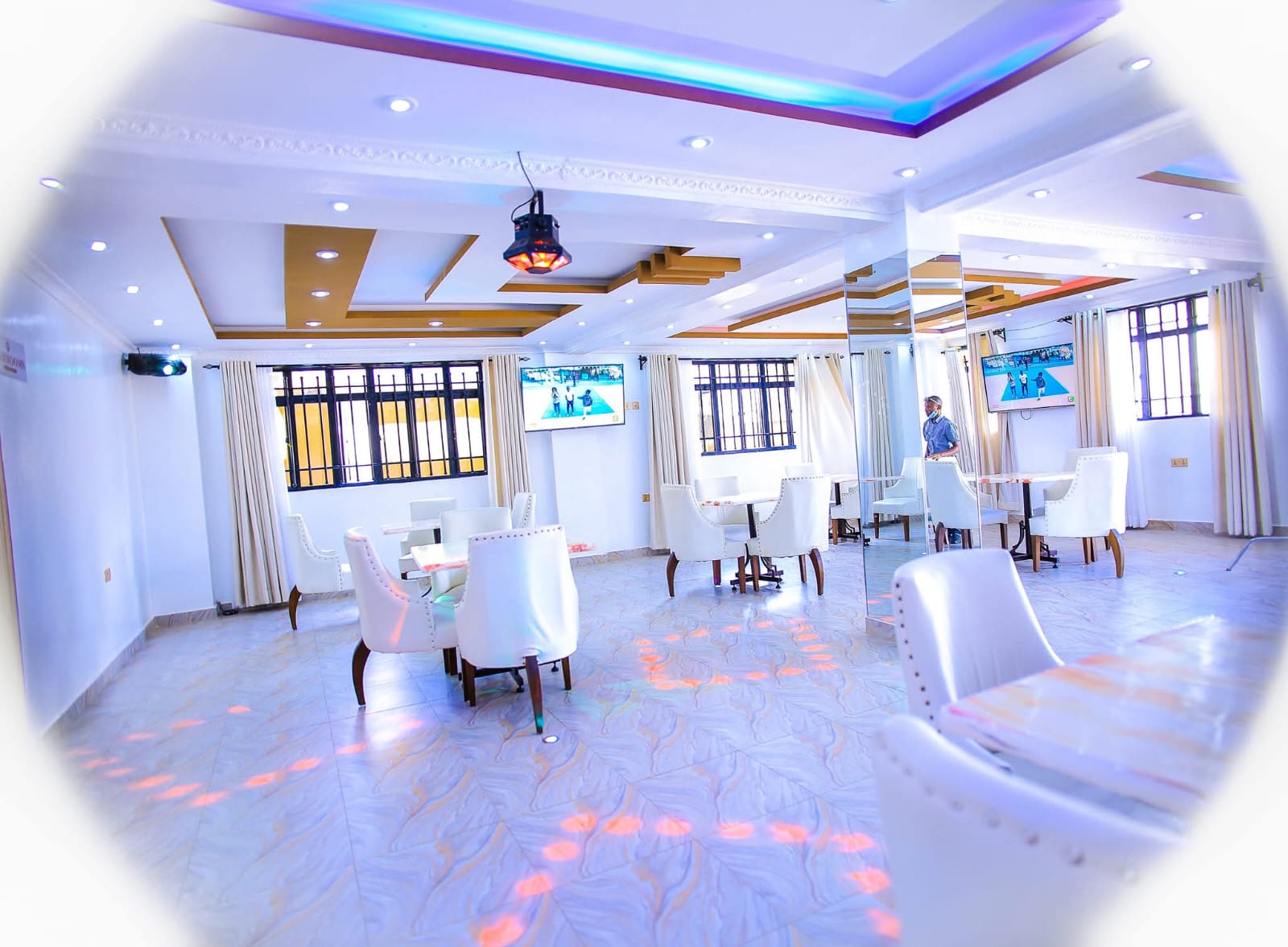 Spacious Emerald Lounge dining area with white leather seating and elegant ceiling design at Kitui Premier Resort