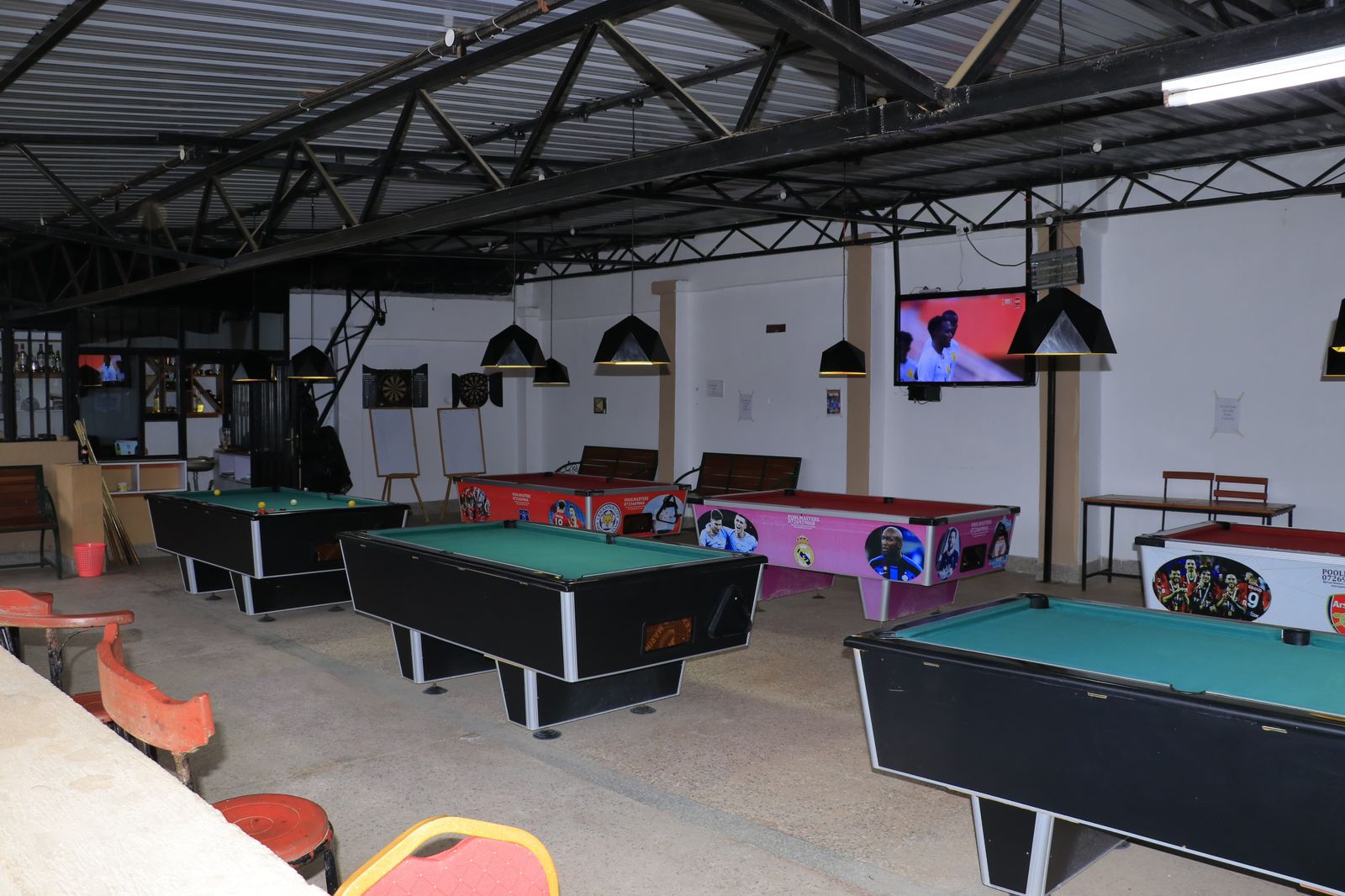 Pool tables in the indoor games lounge at Kitui Premier Resort featuring multiple tables, dartboards, and sports viewing